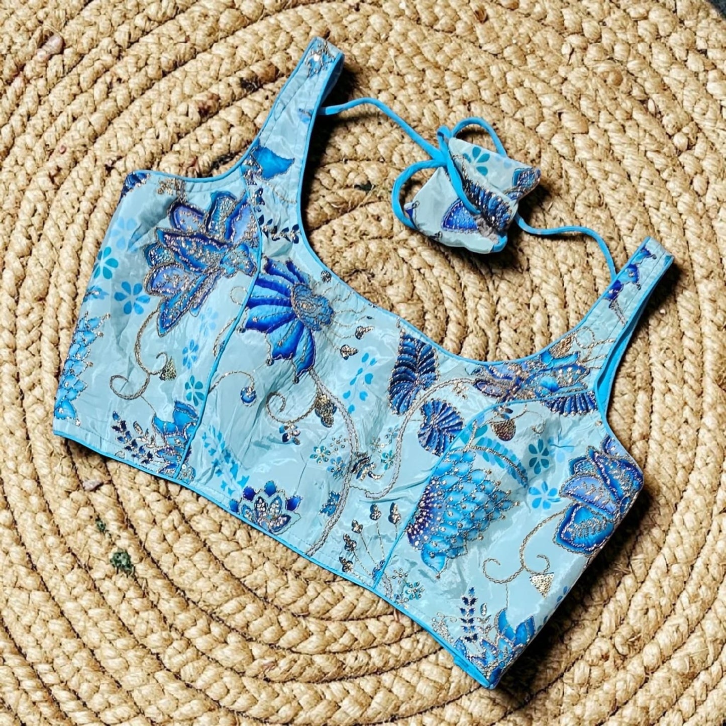 Manishaa's Boutique light blue sleeveless floral print padded saree blouse with blue embroidery and sequin details.