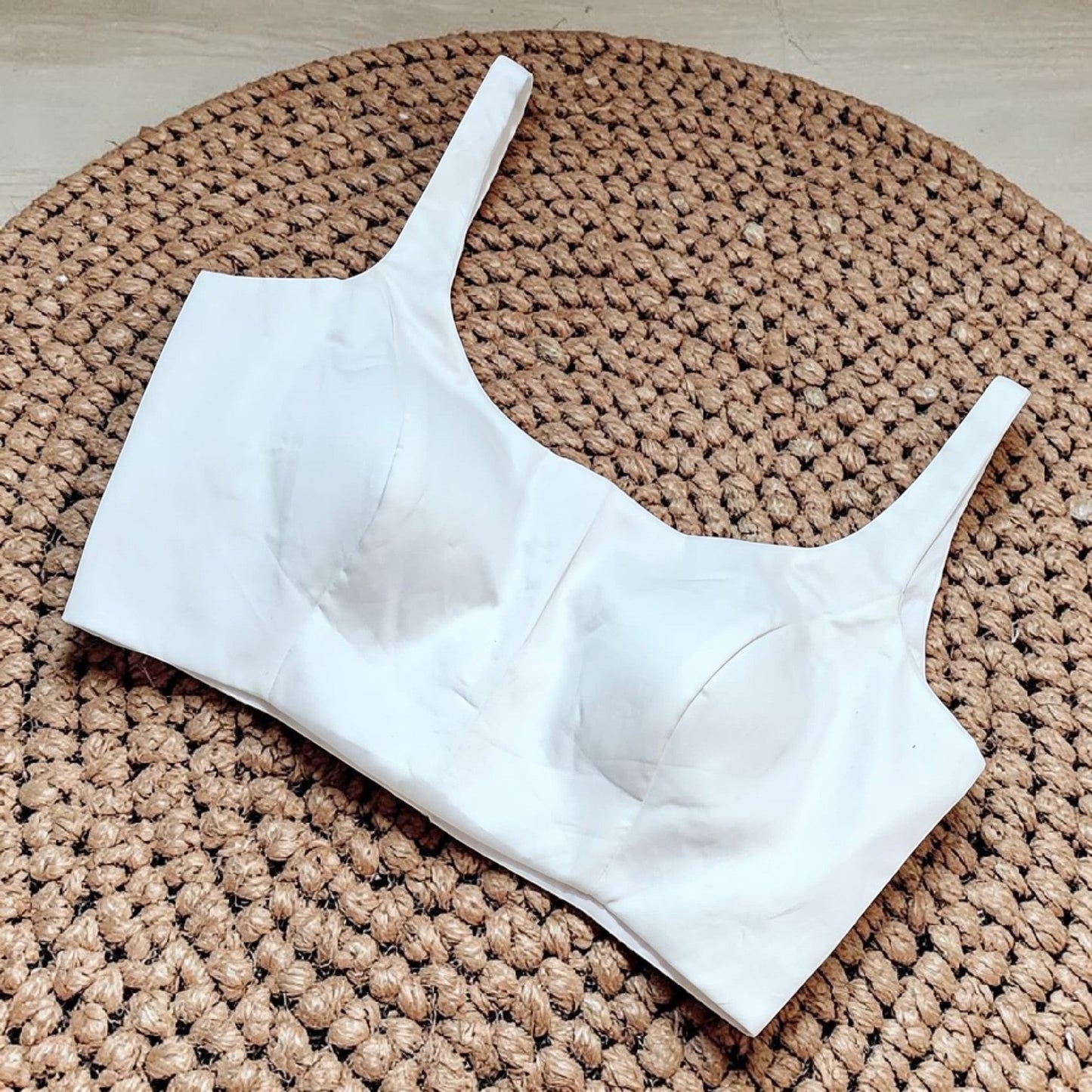 Manishaa's Boutique white sleeveless readymade saree blouse with padded cups and square neckline.