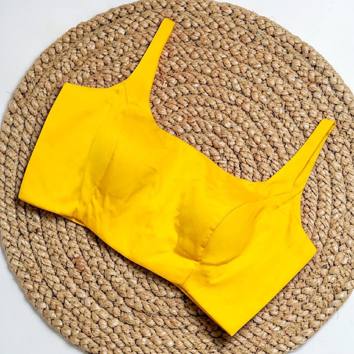 Manishaa's Boutique yellow sleeveless padded saree blouse with elite cut front neck and back tie-up.